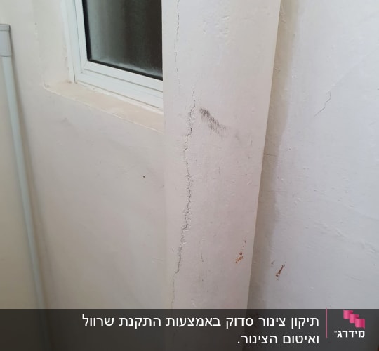 קיר עם סדקים ליד חלון קטן